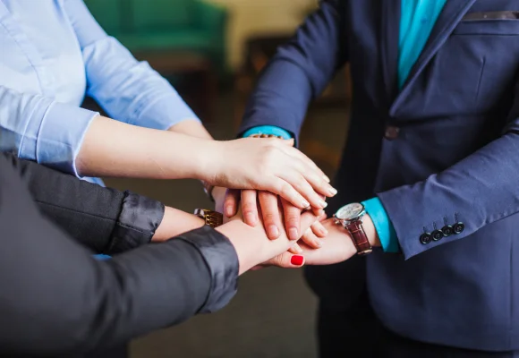 A Image of People joining hands in unity to symbolize teamwork and collaboration.